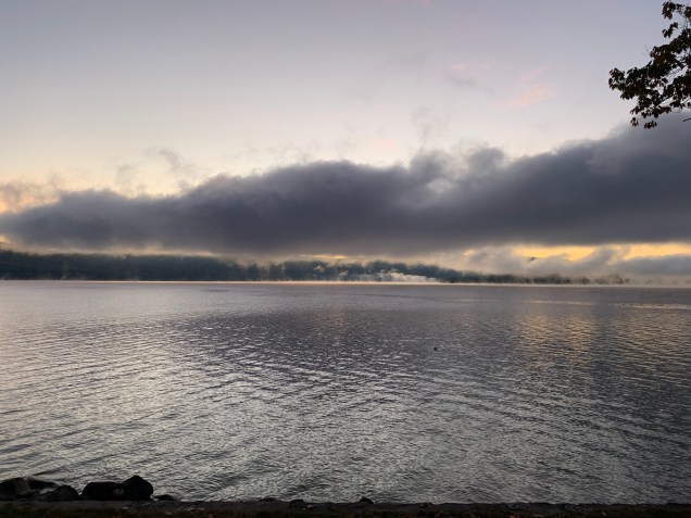 Gray, misty sunrise over a rippling lake.
