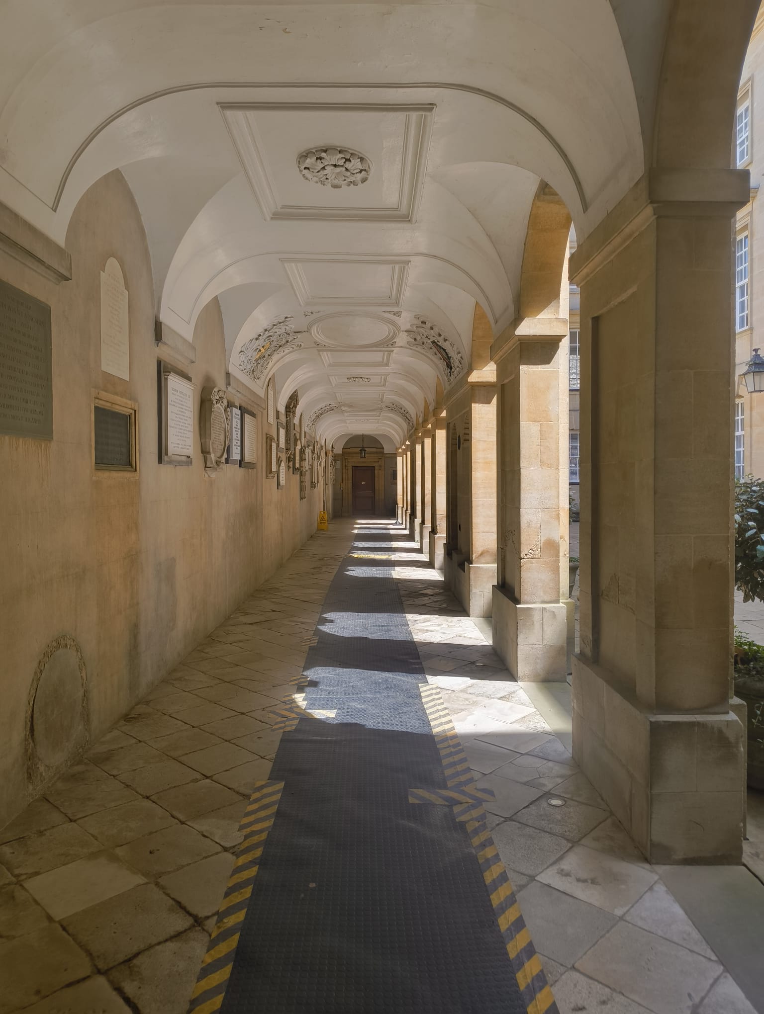 A long corridor full of sunlight and shadows in an Oxford college